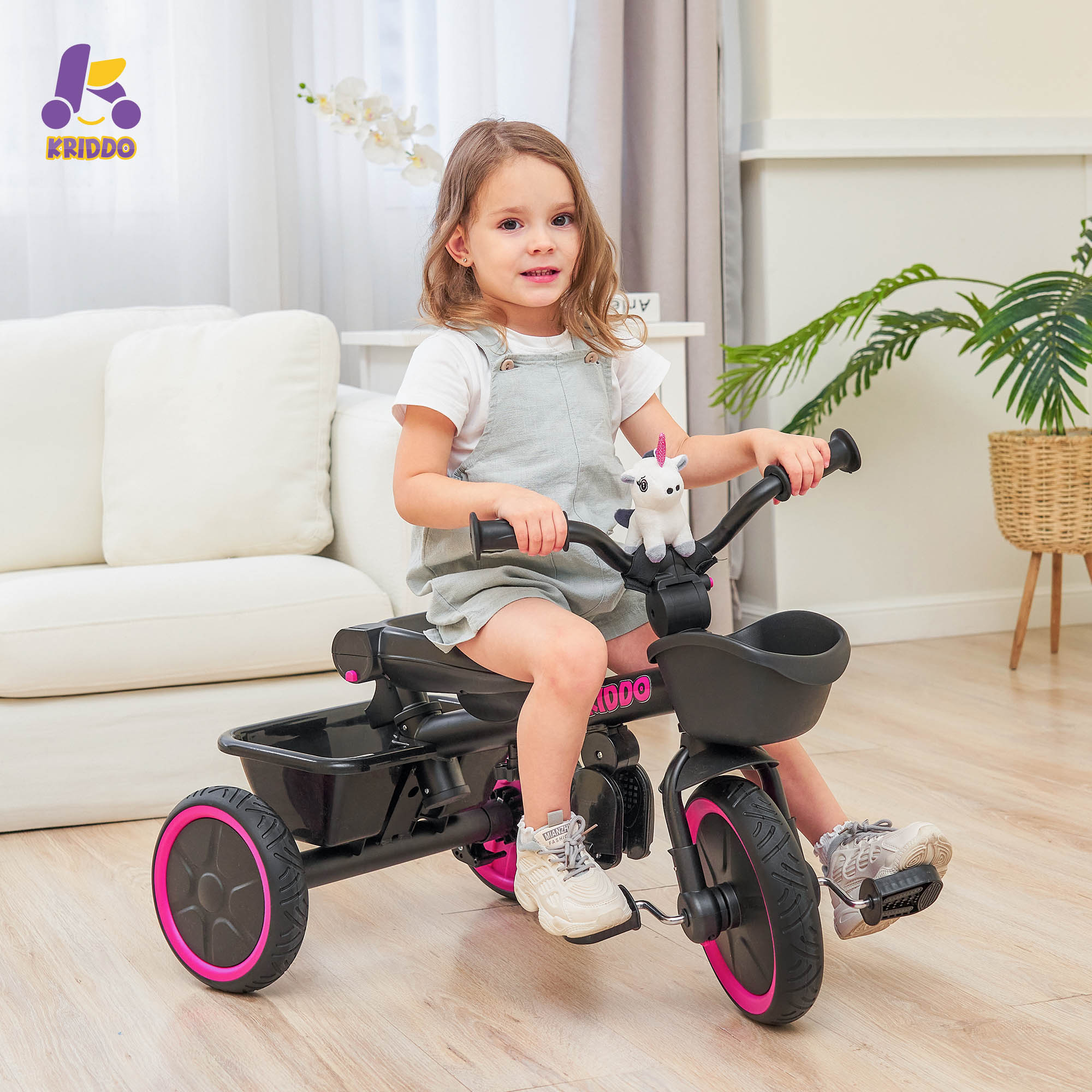 Child riding KRIDDO 7 in 1 tricycle at home.