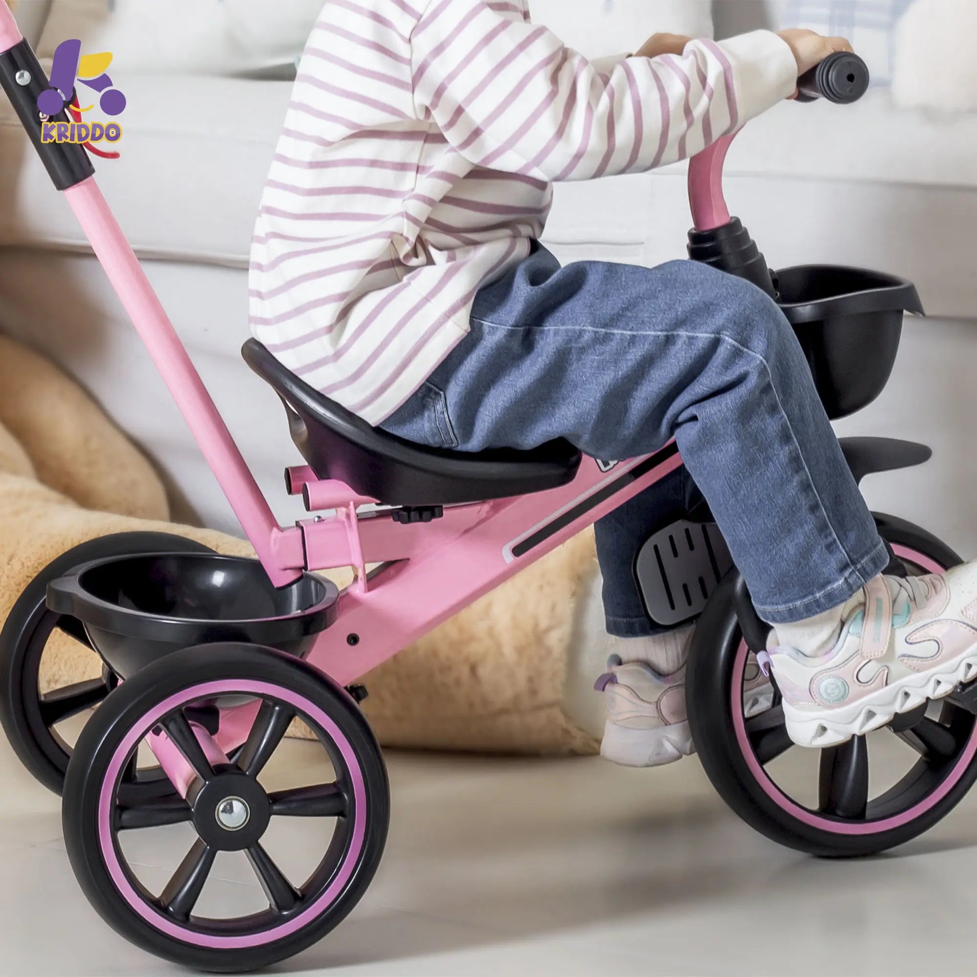 Child sitting on a pink 2 in 1 trike