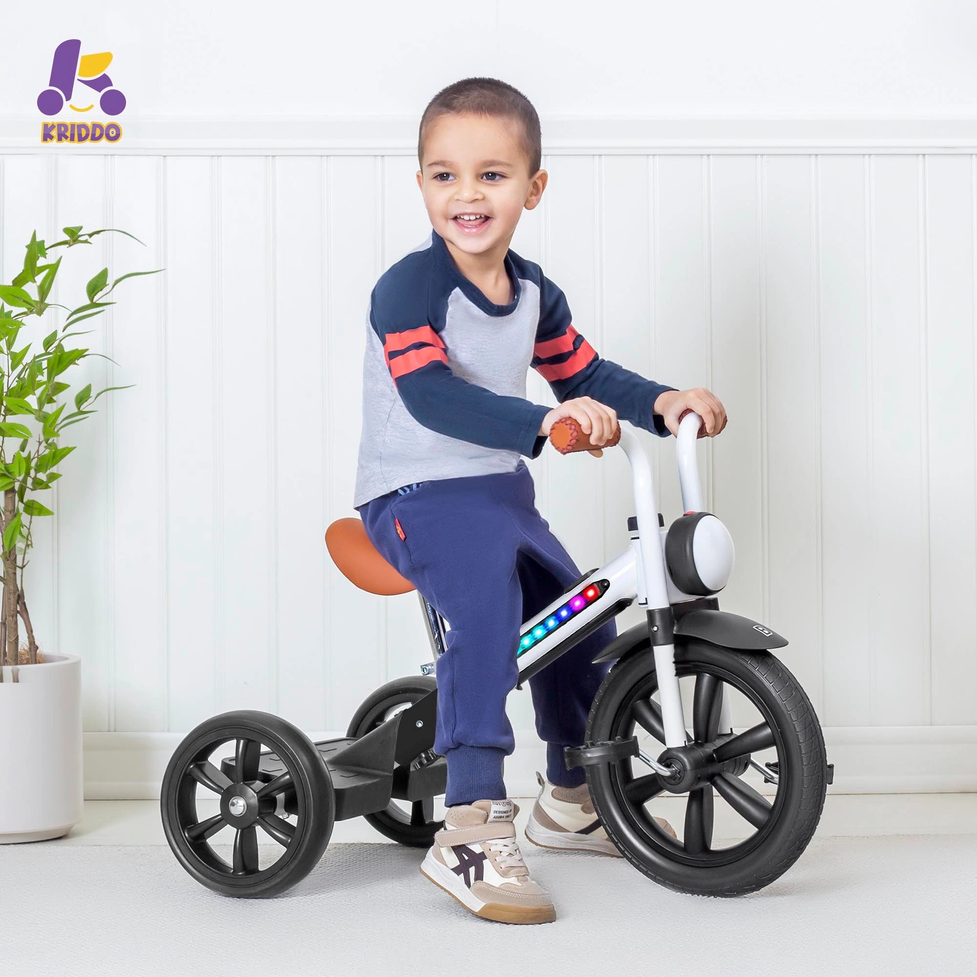 Toddler boy sitting on KRIDDO tricycle with colorful lights