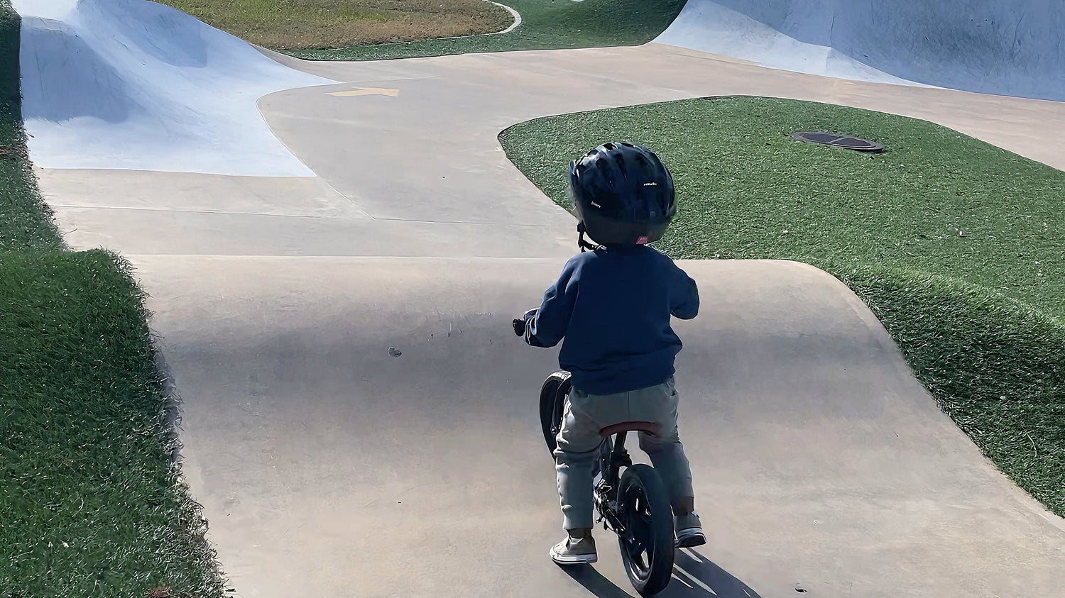 little one riding balance bike in the park
