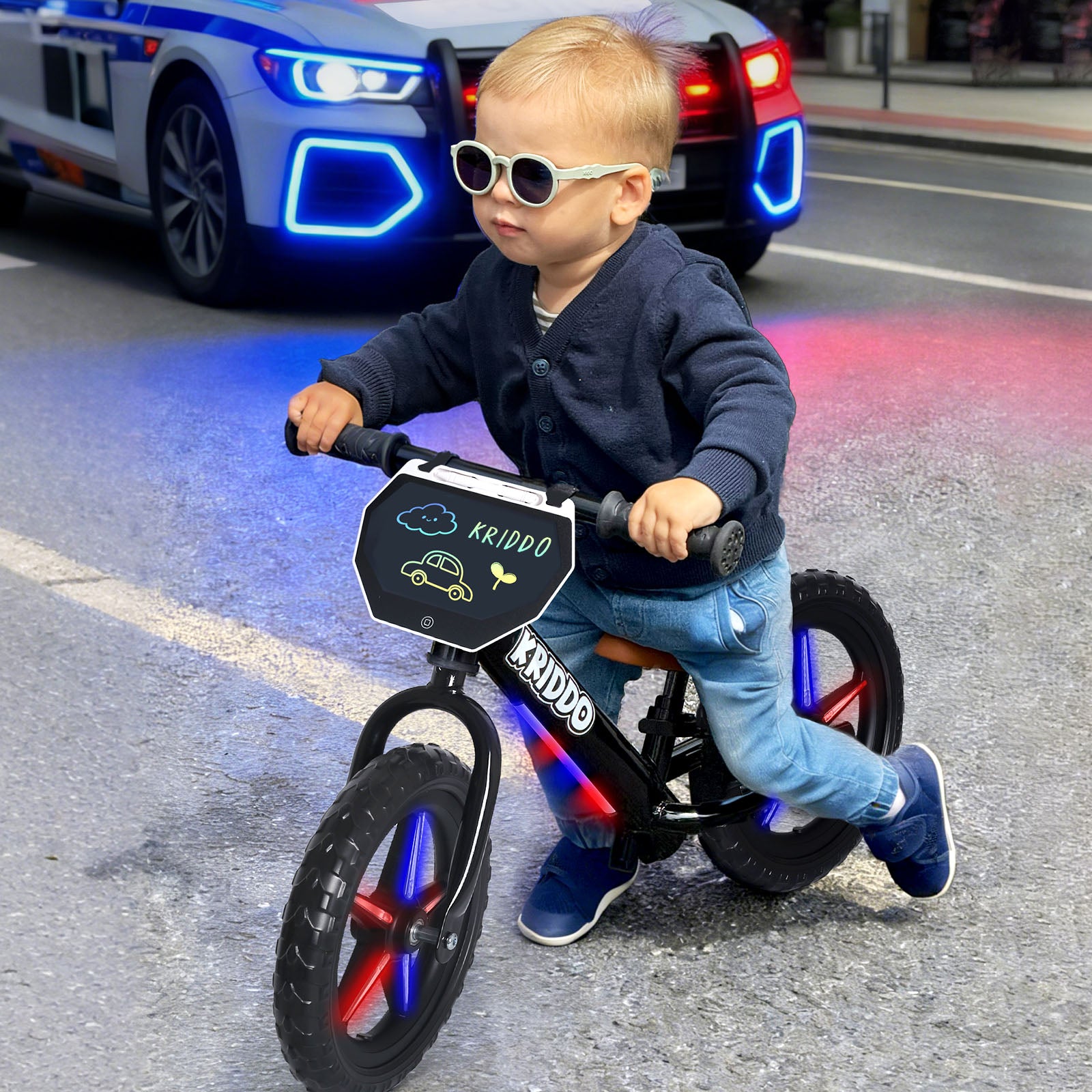 Child riding a light up bike with a car in the background
