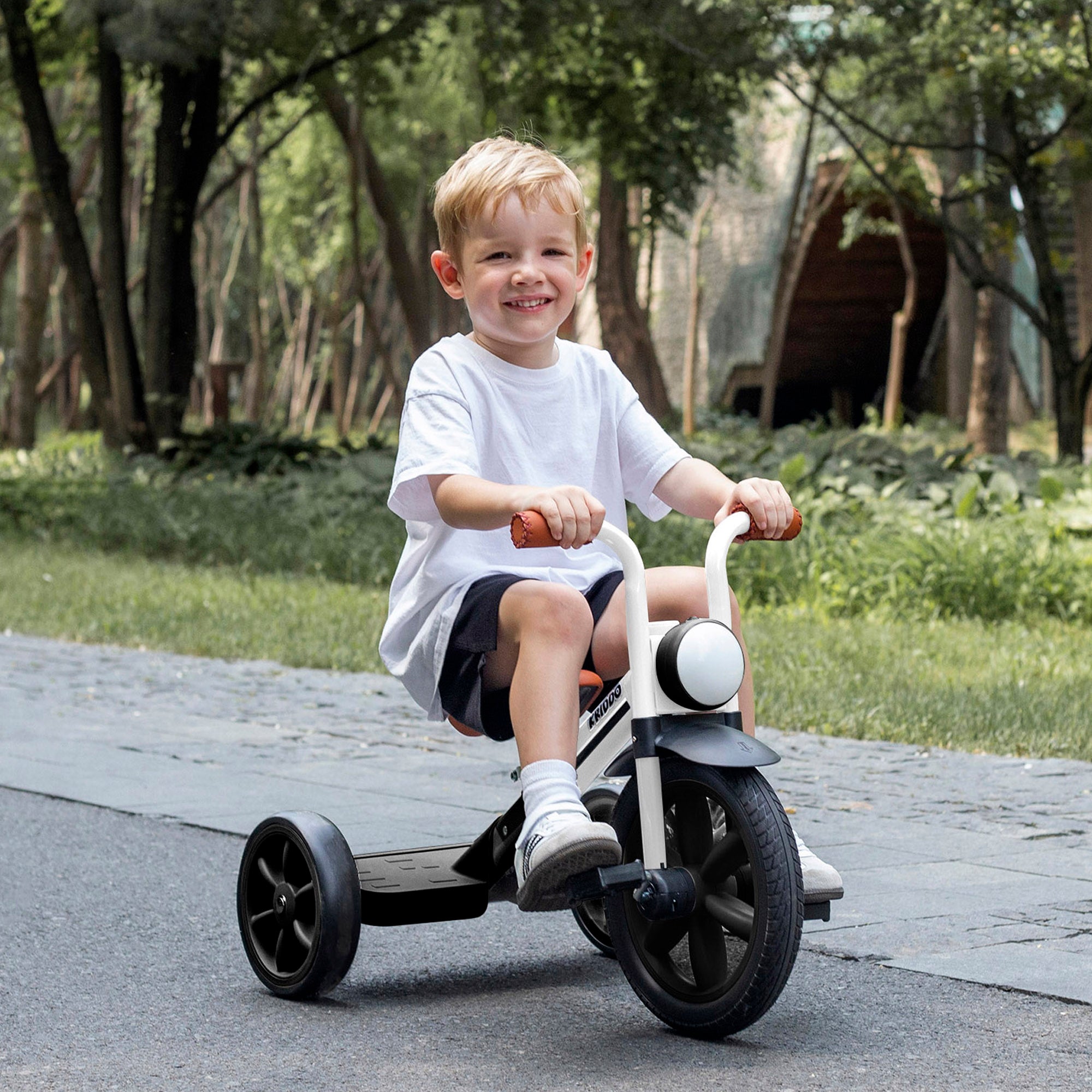 Child riding KRIDDO Buzz Rider tricycle in a park