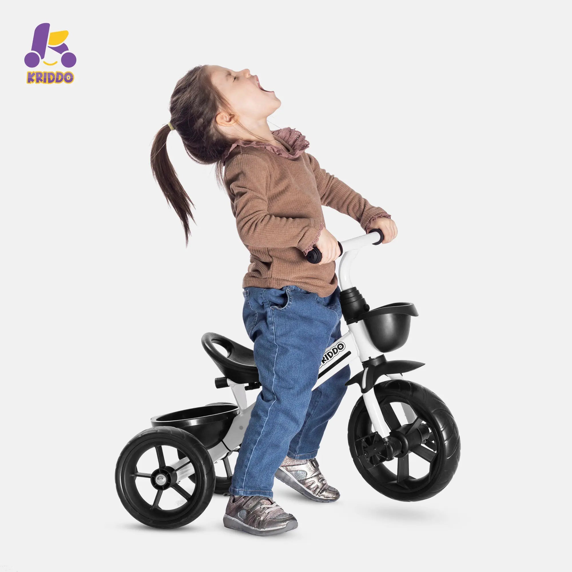 Child standing next to KRIDDO white training tricycle on a white background