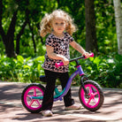 Child on KRIDDO balance bike with glowing wheels in a park